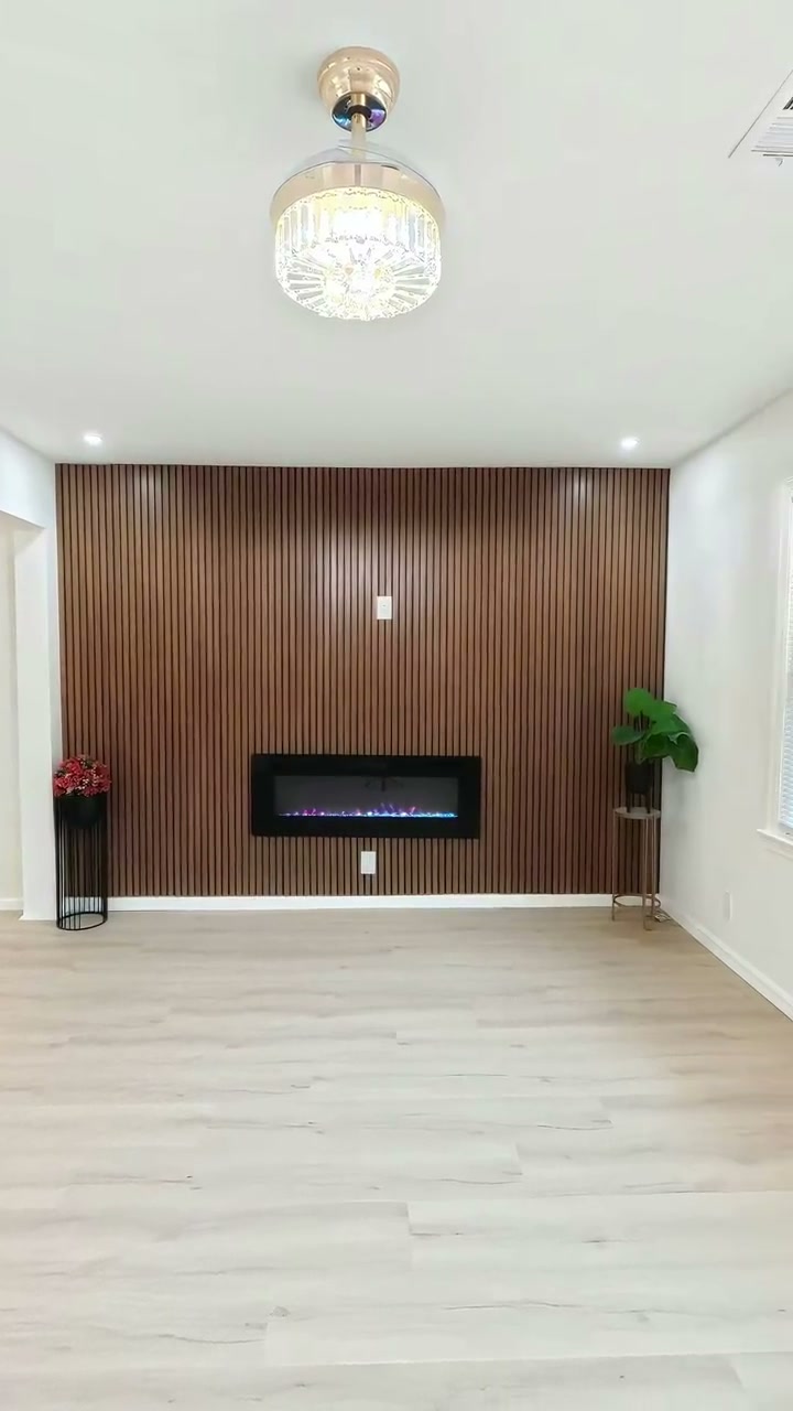 An airy living room with a timber feature wall and fireplace